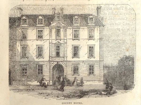 Engraving of a tall classical four-storey hotel with a central arched entrance under a sign reading County Hotel, figures in Victorian dress in front and railings to the right, captioned County Hotel