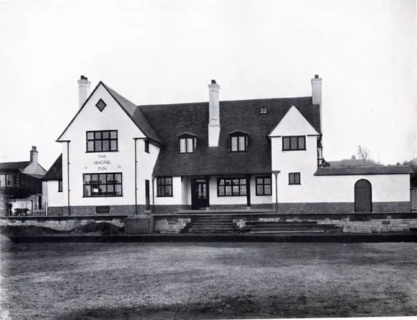 Black and white photograph of a whitewashed gabled building with tall chimneys and dormers, The Magpie Inn painted on the left gable, steps leading up from a lawn in front
