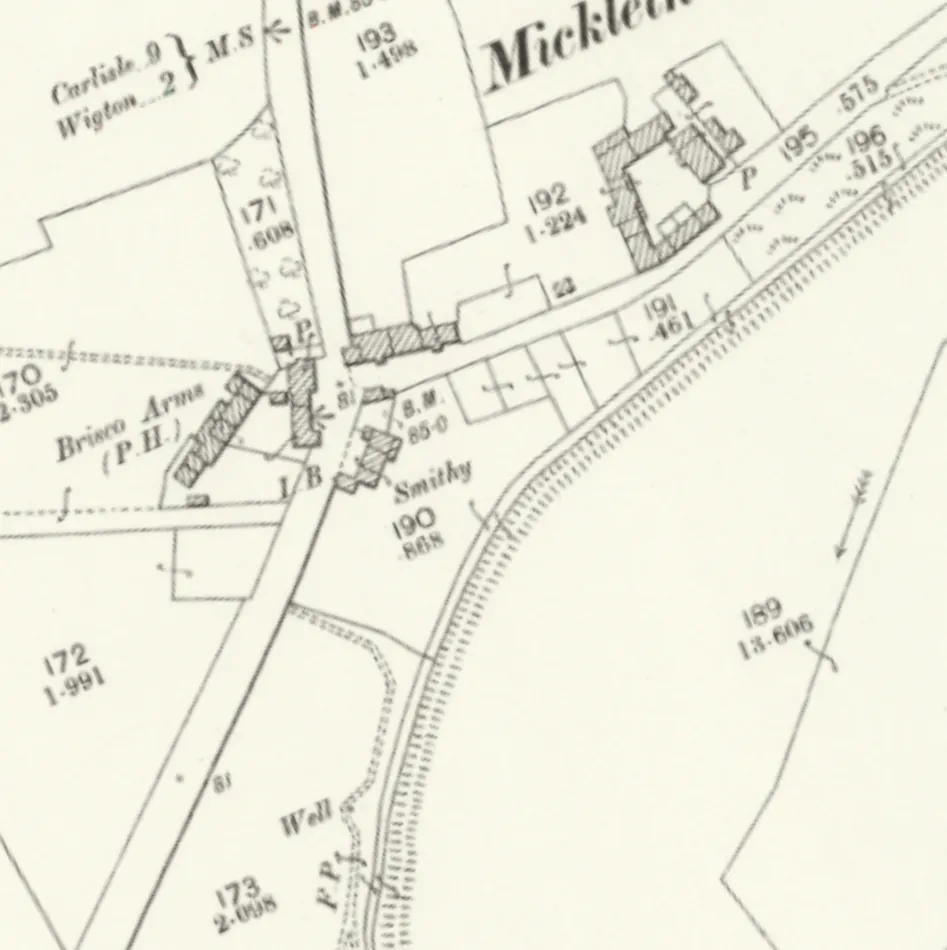 Old Ordnance Survey map of a crossroads hamlet: the Brisco Arms (P.H.) marked as a hatched building on the west side of the main road, a smithy across the lane, a milestone reading Carlisle 9, Wigton 2 just north, and a railway curving past to the east