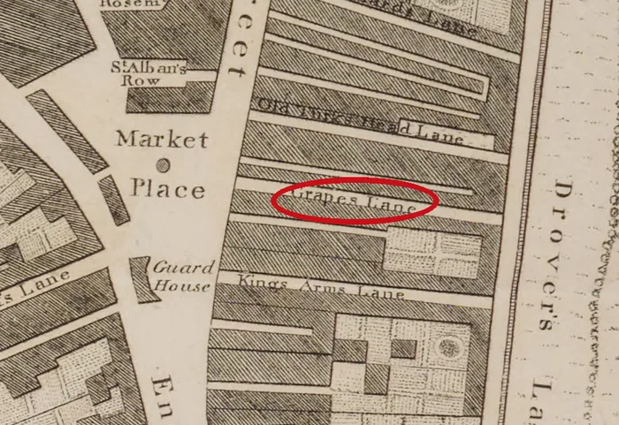 Engraved street plan of the Market Place and the east side of Scotch Street, with long narrow plots running east and a red ellipse round the engraved name Grapes Lane, with Old Turk's Head Lane above it and Kings Arms Lane below